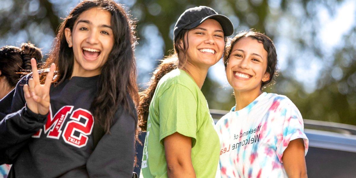 student showing peace symbol and smiling 