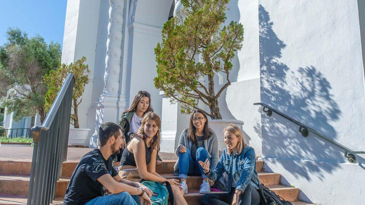 students sit on the steps of school chapel