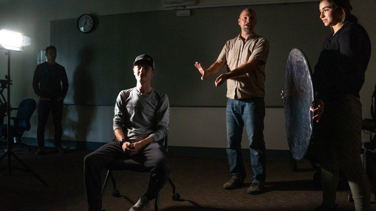 A teacher demonstrating how to light a subject in a lighting class