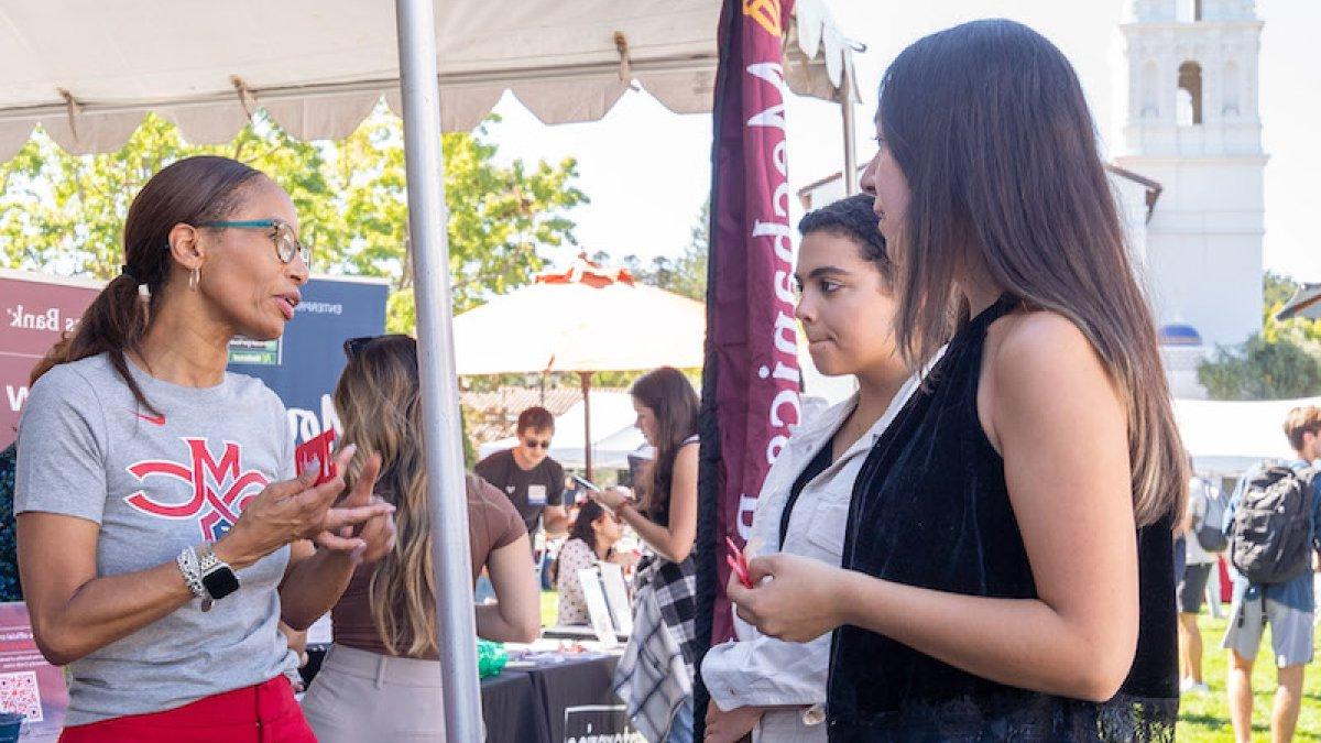 Two 学生 talk with a recruiter at Career Fair